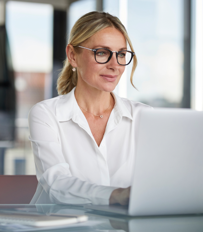 Woman wearing glasses working on laptop in office