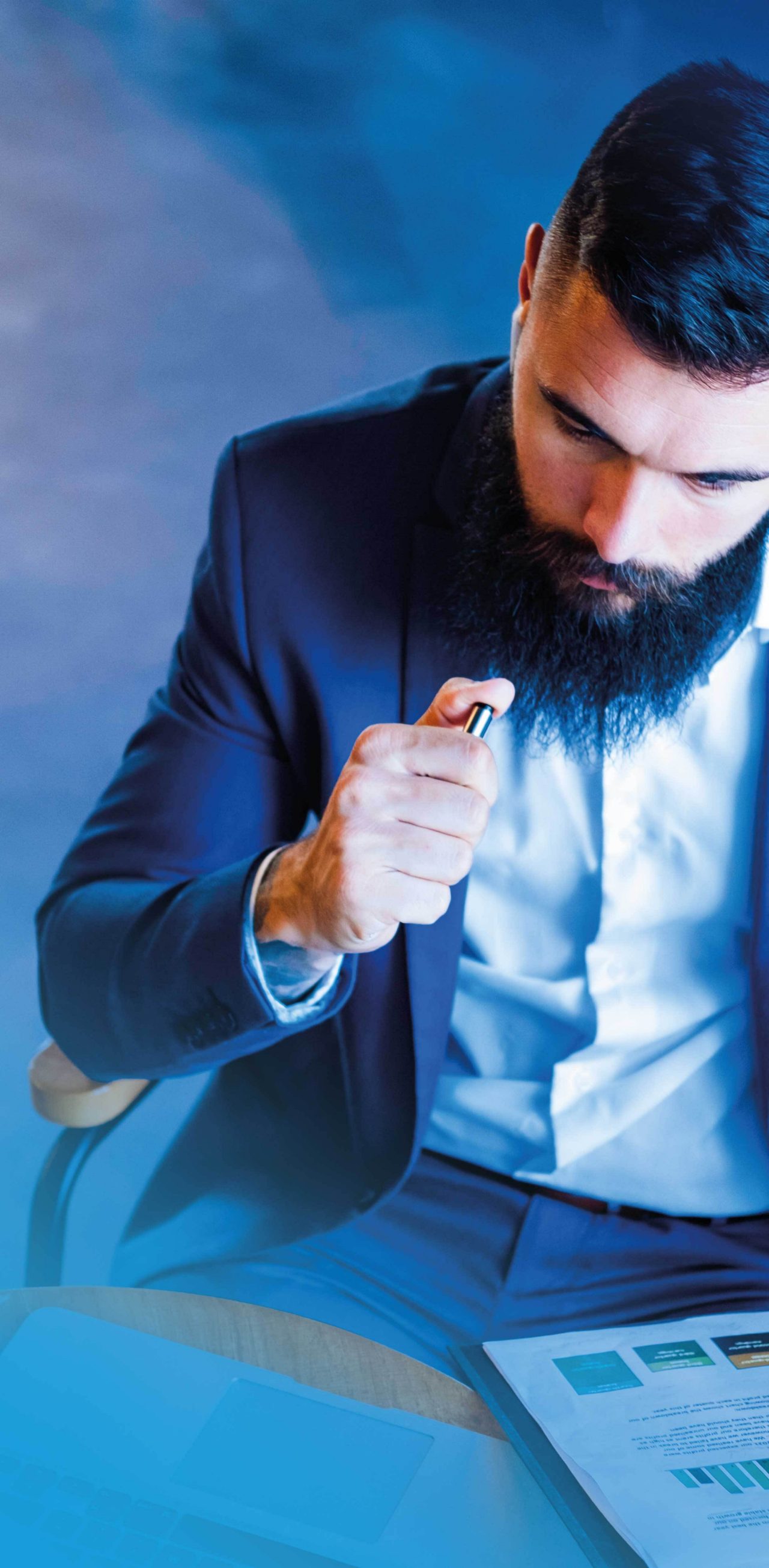 Businessman sitting at desk holding open folder with documents