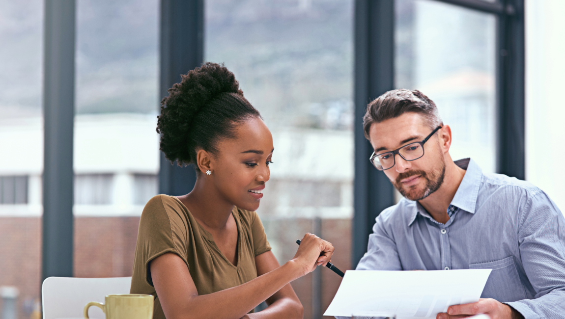 Two colleagues looking over paper in modern office