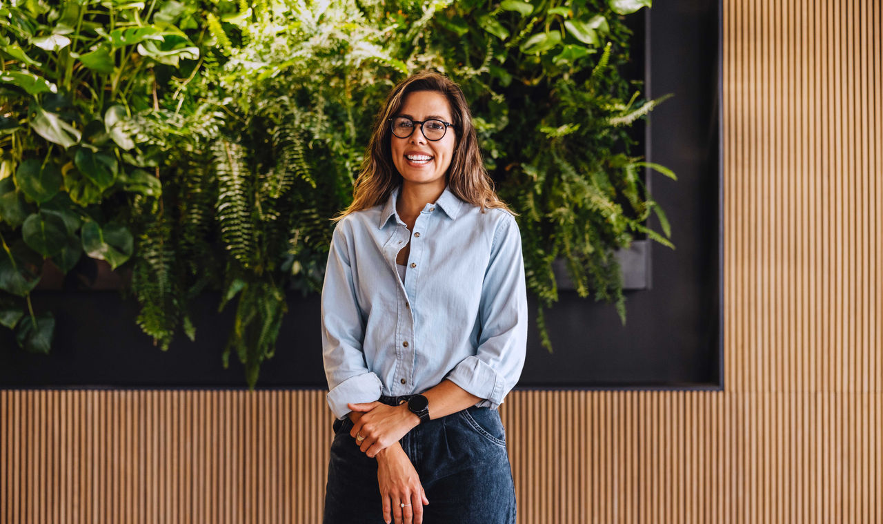 Woman standing in front of a plant wall
