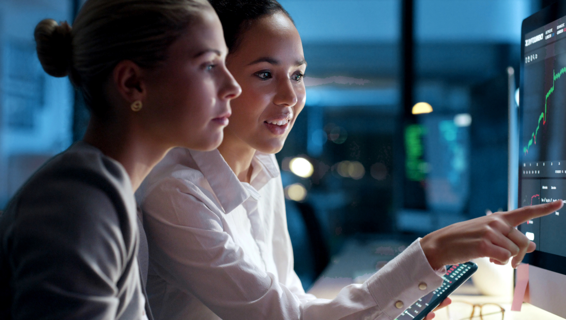 Two colleagues looking and pointing at computer monitor