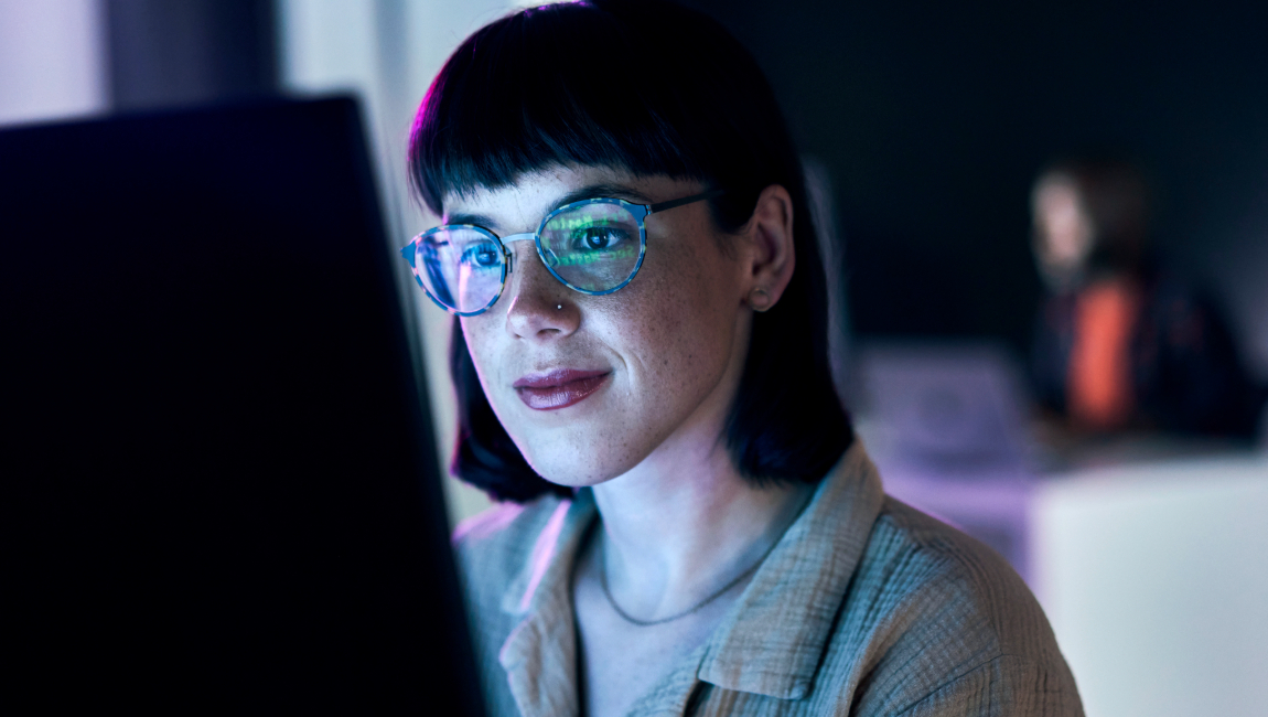Business woman wearing glasses looking at desktop computer