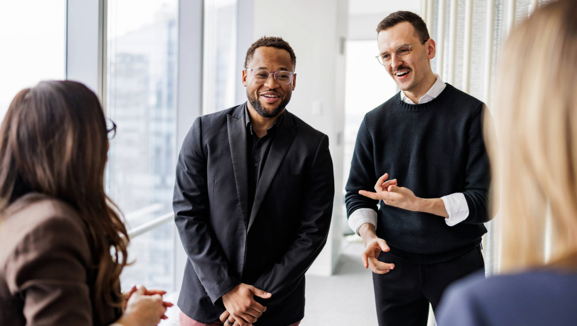 Group of coworkers chatting casually in modern office building