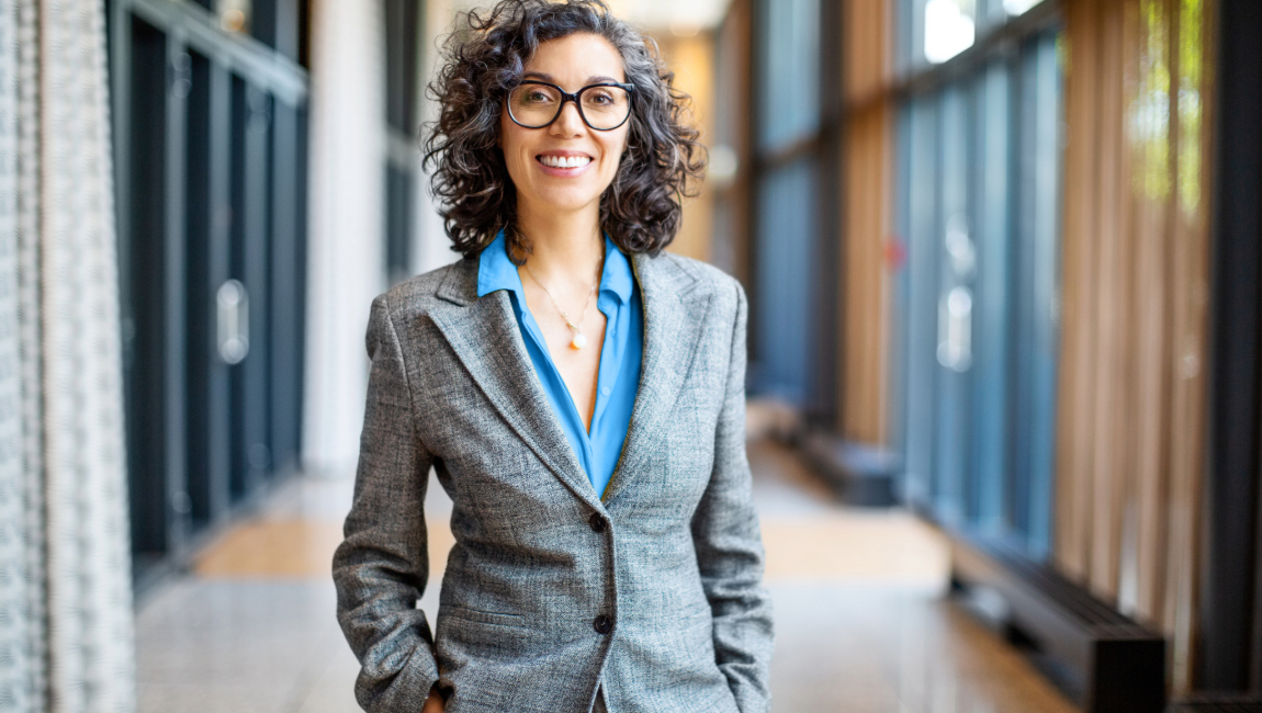 Smiling businesswoman standing with hands in her pockets
