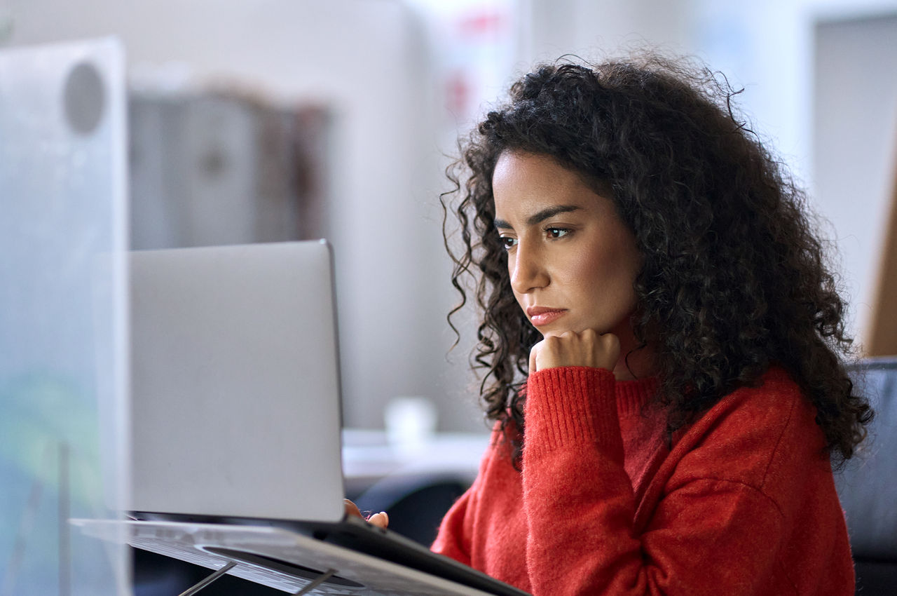 Busy Latin female working on laptop