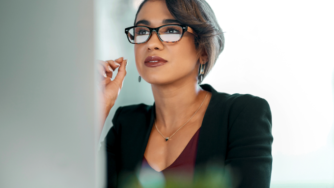 Woman with glasses reading a computer screen