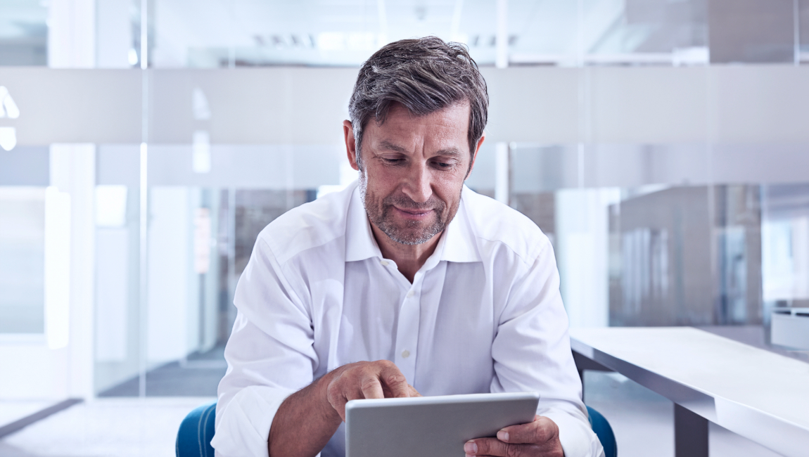 Businessman in modern office looking at digital tablet