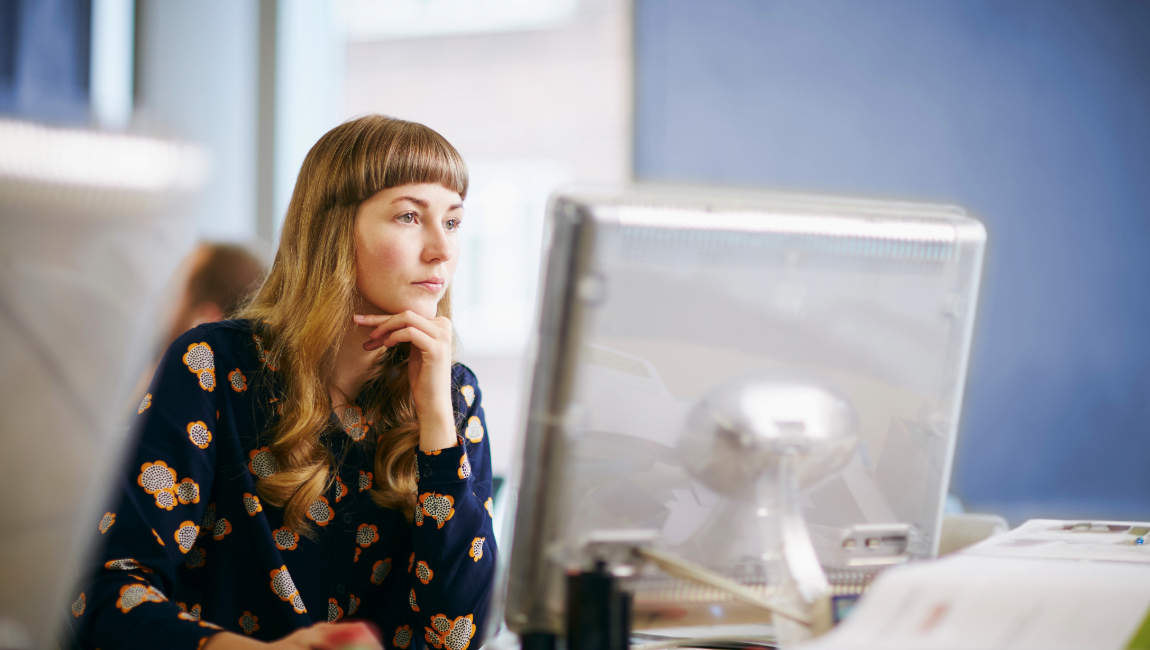 Business woman looking at computer while resting head in hand