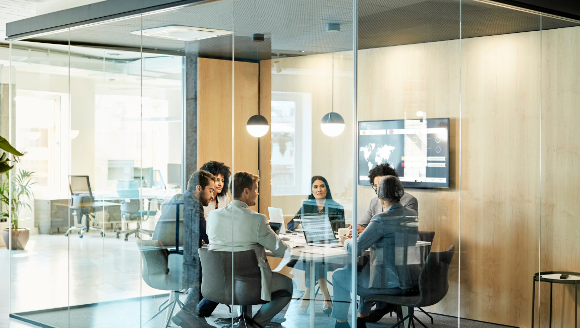 Colleagues meeting in modern, glass meeting room