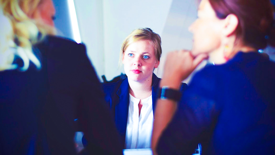 Businesswoman looking at two women